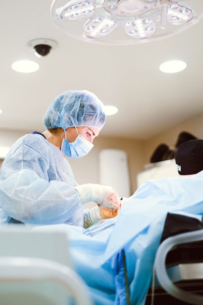 pexels-photo-4421488 Medical professional performing surgery in sterile operating room setting.